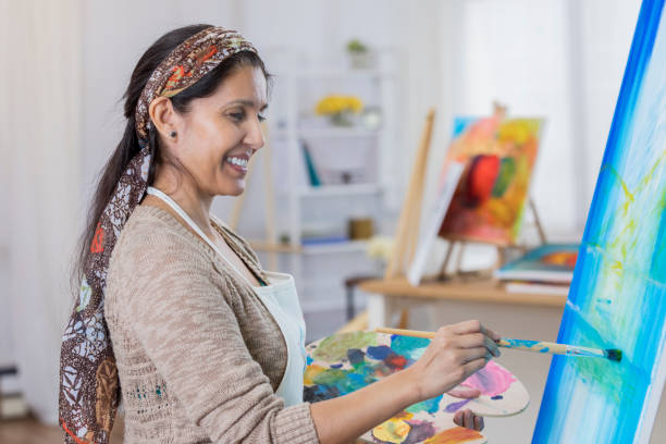 istock Beautiful woman paints in her art studio 649736054