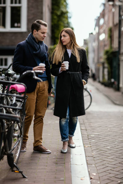 istock Young happy couple taking a stroll with takeaway cups in their hands. bicycle leaning on the fence of the bridge 649738362