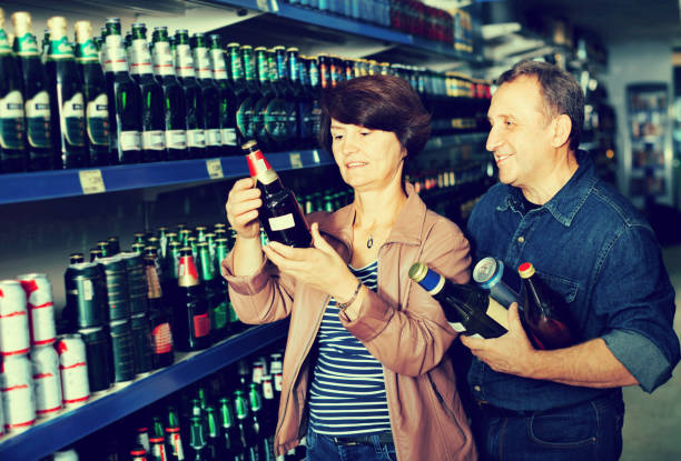 istock Husband and wife selecting a beer at  store 649738524