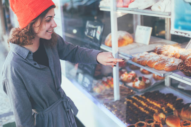 istock Curly woman standing in front of showcase with sweets 649741492