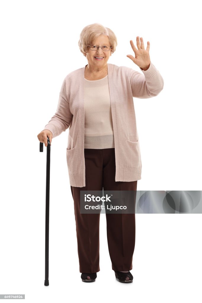 Femme âgée avec une ondulation de canne marche - Photo de Saluer de la main libre de droits