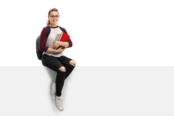 istock Cheerful female student with backpack and books sitting on panel 649749212