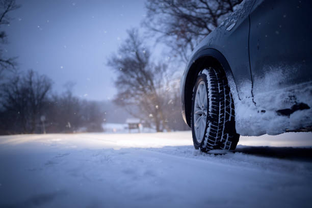 istock Car and falling snow in winter on forest road 649750992