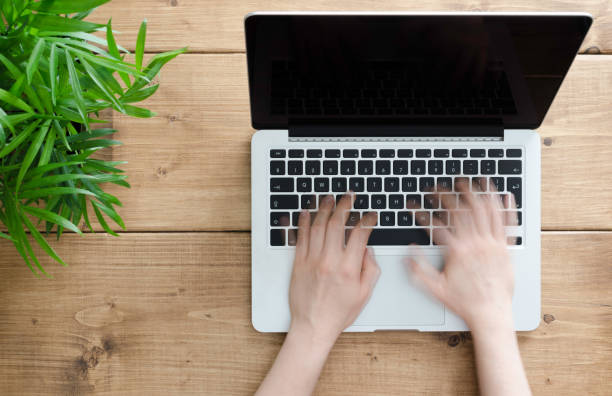 istock Two hands are typing on a laptop with blank screen. 649764492