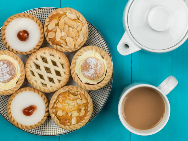 piatto di torte o crostate individuali assortite con una pentola di tè - tea cakes foto e immagini stock