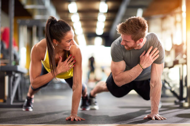 mann und frau stärken hände - athlete push ups muscular build female stock-fotos und bilder