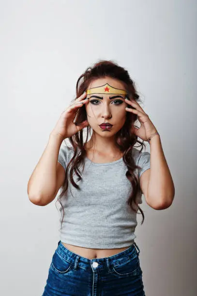 Photo of Studio portrait of girl with asian appearance and bright make up with red star on forehead