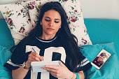 Woman making notes in bed