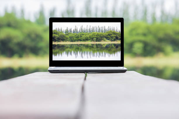 istock laptop over wooden table outdoors and blurred background 649777094