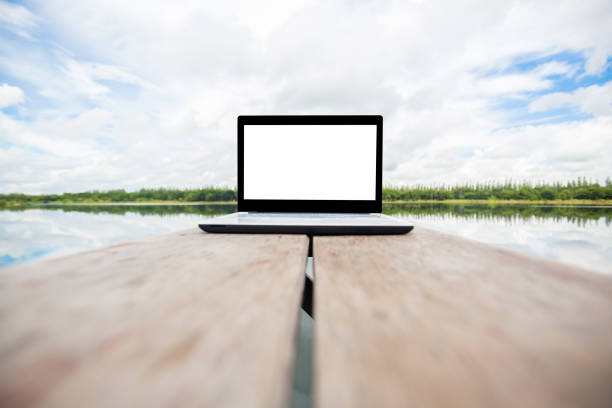 laptop over wooden table outdoors and sky background