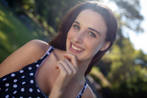 Portrait of woman with hand on chin while standing in park