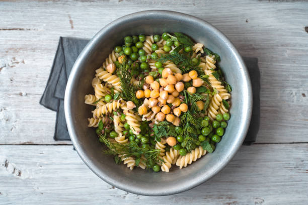 Salad with fusilli, chickpeas, grass in a metal bowl stock photo