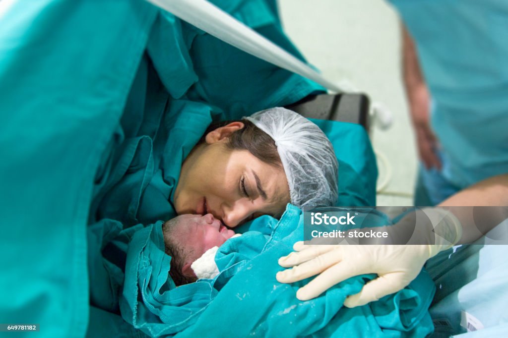 Young mother giving birth to a baby Childbirth Stock Photo