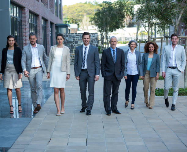istock Smiling businesspeople walking in office building 649781784