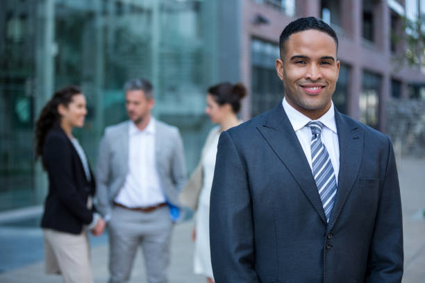 istock Smiling businessman standing in office building 649781850
