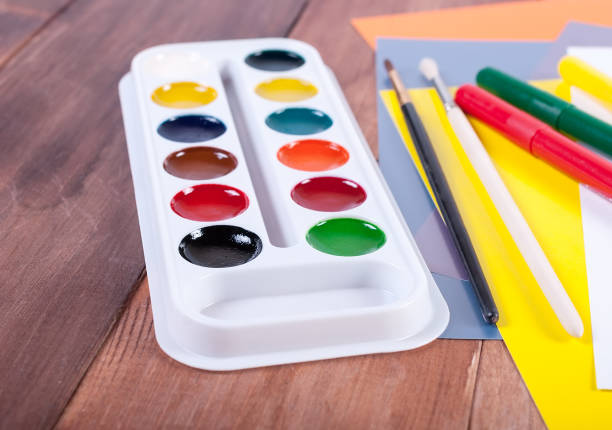 drawing paper. Brush and paint on a wooden background