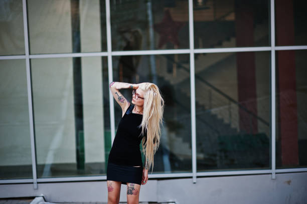 istock Young blonde tattoo girl background high-tech windows architecture 649795438