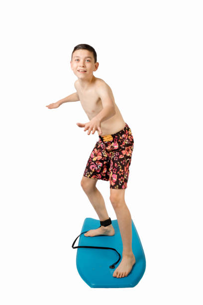 istock Teenage boy standing on a body board 649804320