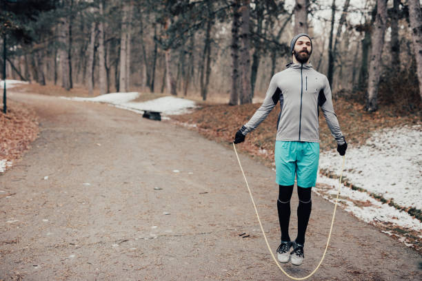 istock Muscular man skipping rope in the park 649813516