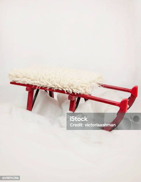 Red Sledge On Fake Snow With Sheepskin On Top Stock Photo - Download Image Now - Art, Christmas, Decoration
