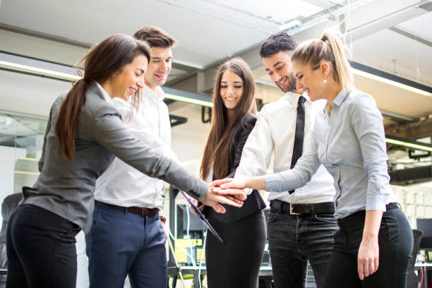 Business team joining hands together in the office.
