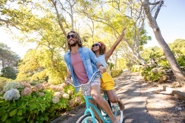 istock Couple having fun while cycling in the park 649825608