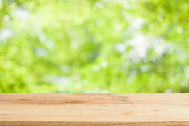 istock Wood table top on bokeh Green background 649829982