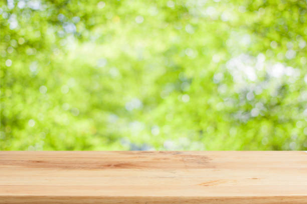 istock Wood table top on bokeh Green background 649830420