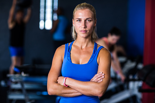 Portrait of serious woman with arms crossed  while standing in gym