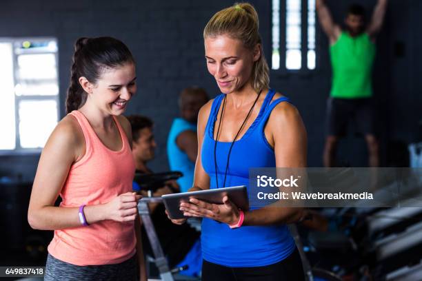 Smiling Friends With Digital Tablet In Gym Stock Photo - Download Image Now - Fitness Instructor, Females, Digital Tablet