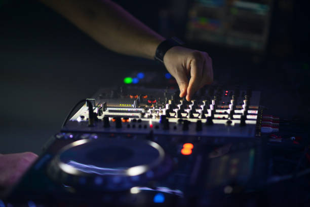 istock Dj hands on equipment deck and mixer with vinyl record at party 649852538