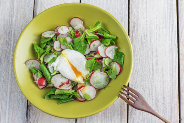 Top View on a Radish Salad with Poached Egg with Wooden Fork stock photo