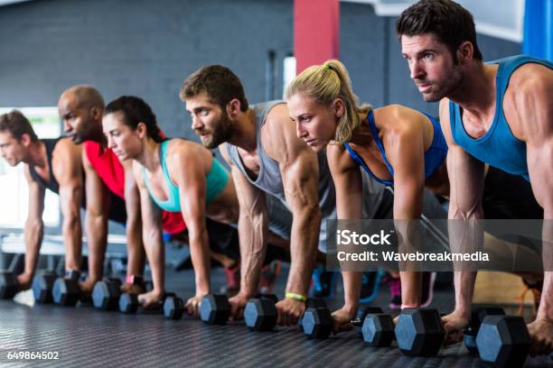 People Doing Pushups With Dumbbell In Gym Stock Photo - Download Image Now - 20-29 Years, 25-29 Years, 30-34 Years