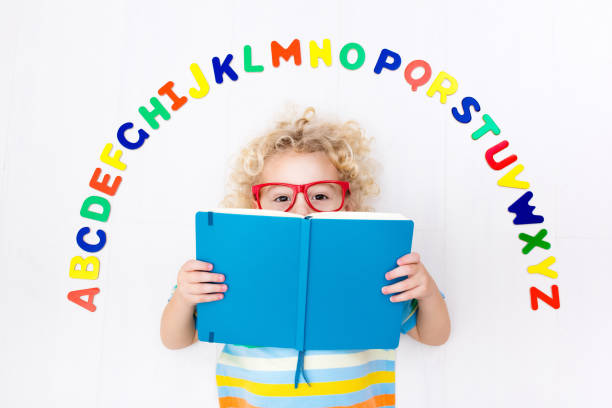 istock Child learning letters of alphabet and reading 649875464