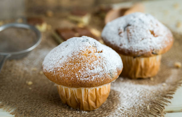 istock Muffins powdered by sugar on jute and white wooden background. 649875532