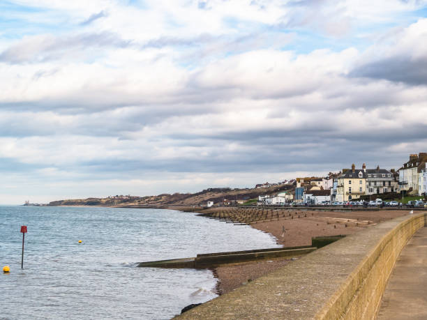 Herne Bay, Kent, UK The coastline looking towards Reculver Towers of Herne Bay, Kent, UK. The pebble beach has water breakers, groynes protecting the beach. herne bay photos stock pictures, royalty-free photos & images