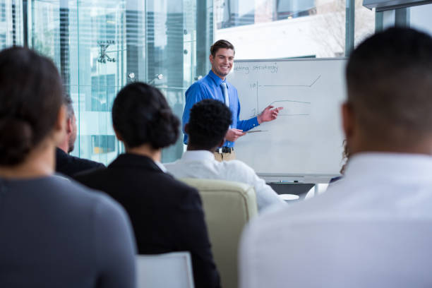 istock Businessman discussing on white board with coworkers 649881884