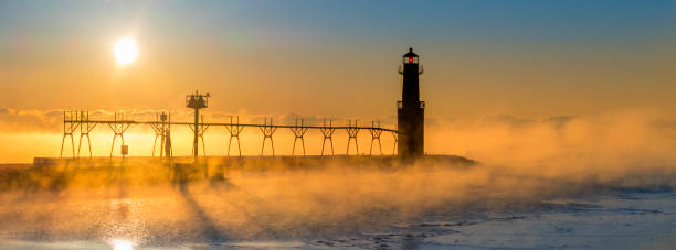 istock Cold steaming Lake Michigan at Sunrise with iconic Lighthouse 649894196
