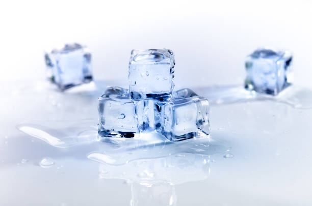 istock Iced cubes melting on a white table with reflection. Water. Melting of ice. 649897930