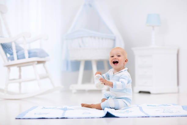 istock Baby boy drinking milk in sunny nursery 649900818