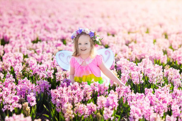 piccola bambina in costume fata, giocando nel fiore di campo - 11088 foto e immagini stock