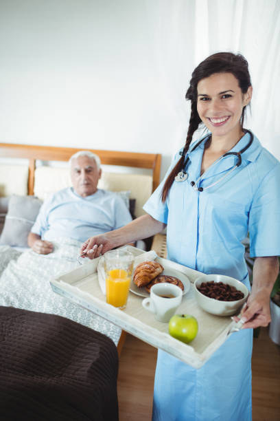 istock Nurse serving breakfast to senior man 649902468