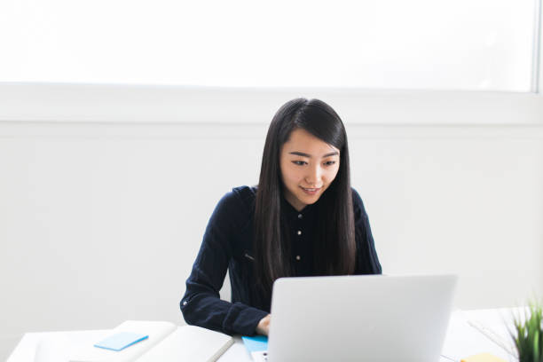 istock Asian businesswoman sending emails 649915724