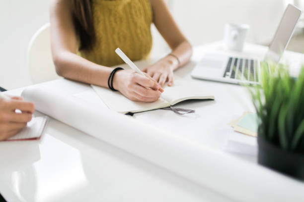 istock Close up of businesswomen making notes 649915950