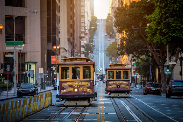 San Francisco Cable Cars on California Street at sunrise, California, USA Classic view of historic traditional Cable Cars riding on famous California Street in beautiful early morning light at sunrise in summer, San Francisco, California, USA cable car photos stock pictures, royalty-free photos & images