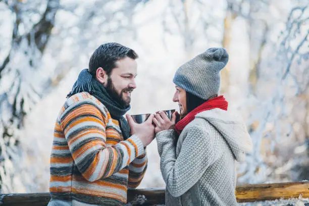 Photo of Young couple in front of log cabin