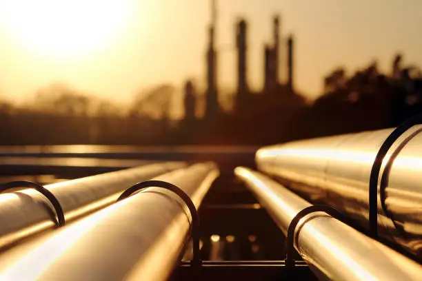 Photo of golden sunset in crude oil refinery with pipeline system