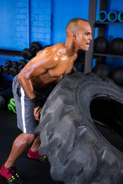 istock Aggressive male athlete pushing tire in gym 649957186