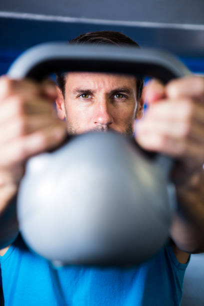 istock Portrait of serious man showing kettlebell 649957400