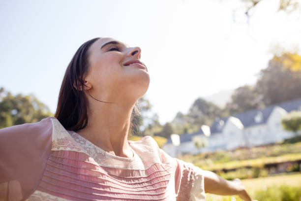 istock Woman standing with arms outstretched in park 649971700